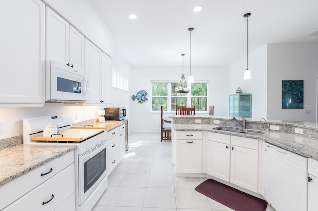 kitchen featuring white cabinetry, sink, light stone counters, pendant lighting, and white appliances