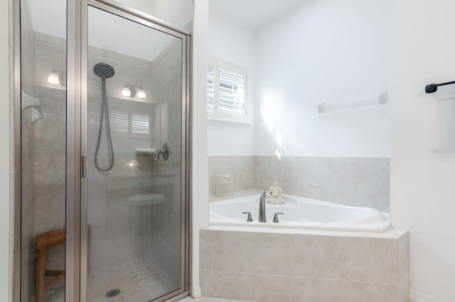 bathroom featuring shower with separate bathtub