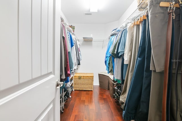 spacious closet with dark hardwood / wood-style flooring