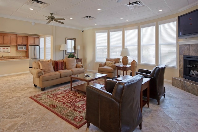 living area featuring baseboards, a fireplace, and visible vents