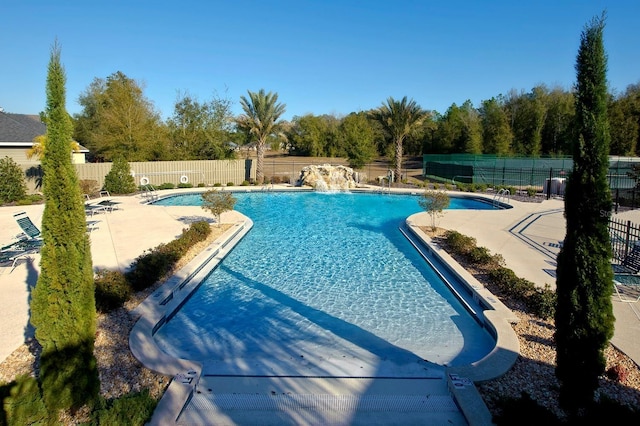 community pool featuring a patio and fence private yard