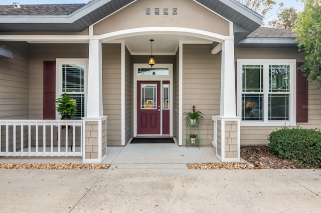 property entrance with a porch and roof with shingles