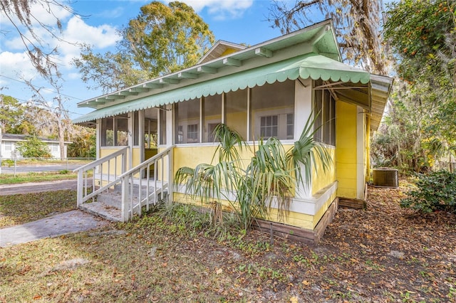 view of front facade with a sunroom and central AC