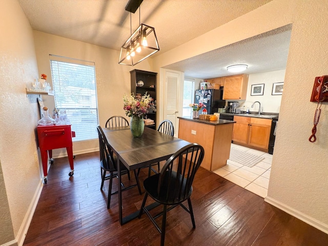 dining room with a textured ceiling, light hardwood / wood-style flooring, and sink