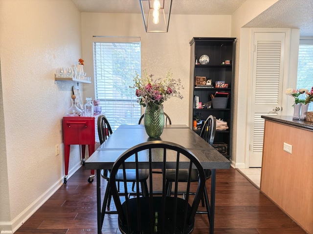 dining room featuring dark hardwood / wood-style flooring and a textured ceiling