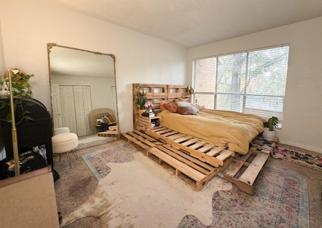 carpeted bedroom featuring a textured ceiling and a closet