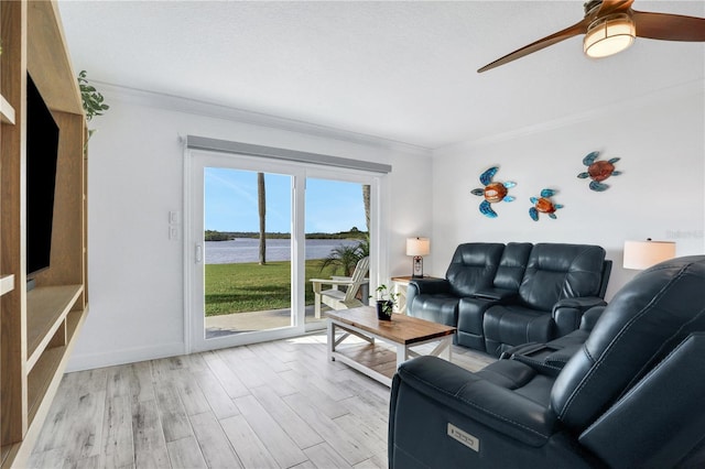 living room with a water view, ceiling fan, light wood-type flooring, a textured ceiling, and ornamental molding