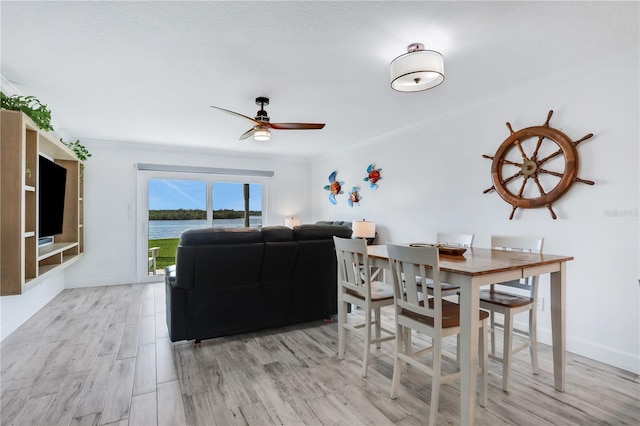 dining room featuring light wood-type flooring, ceiling fan, and ornamental molding