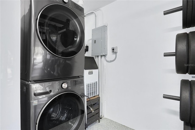 laundry room with electric panel and stacked washer and clothes dryer