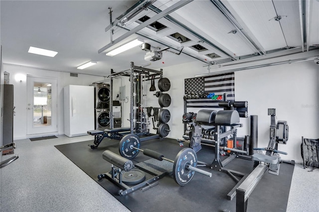 gym featuring stacked washing maching and dryer