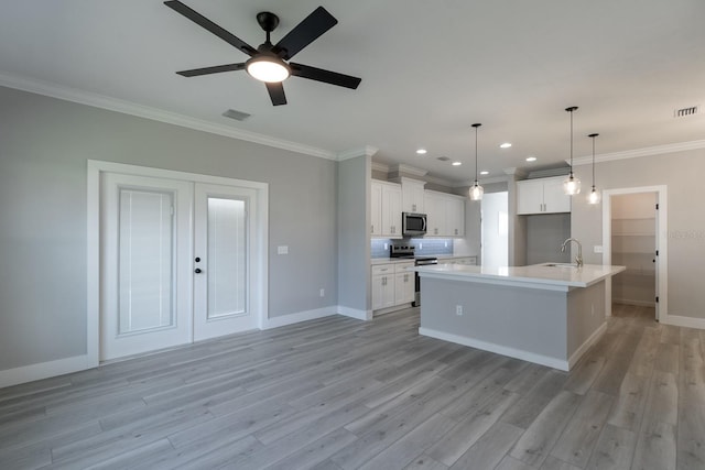 kitchen featuring visible vents, crown molding, appliances with stainless steel finishes, a ceiling fan, and a sink