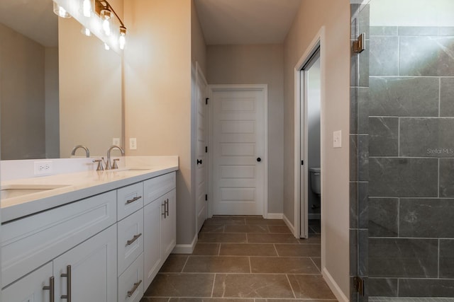 full bathroom with a sink, tiled shower, toilet, and double vanity