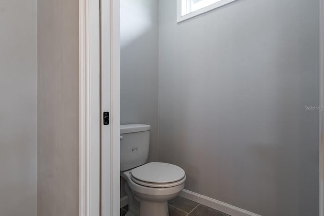 bathroom featuring tile patterned floors, baseboards, and toilet