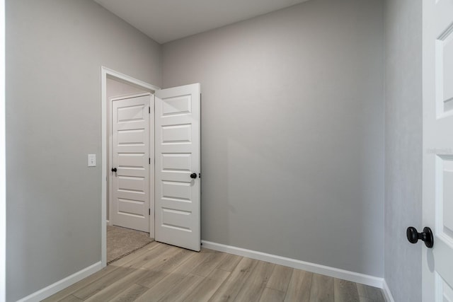 empty room with baseboards and light wood finished floors