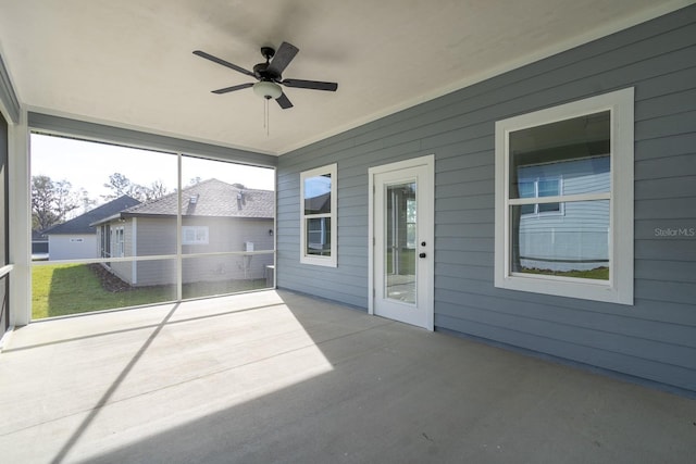 unfurnished sunroom with a ceiling fan