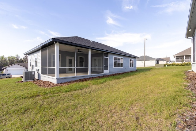 back of house with central air condition unit, a yard, a sunroom, and a shingled roof