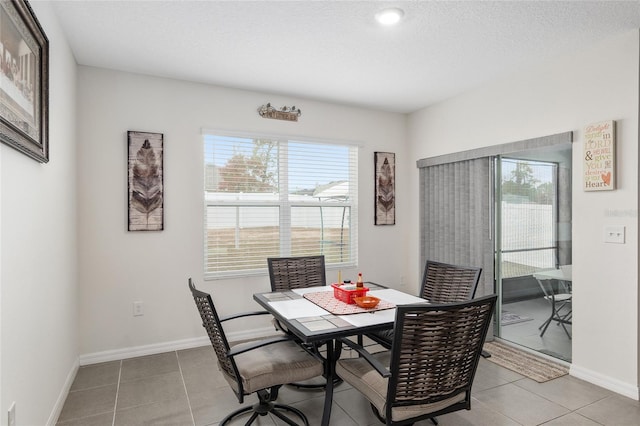 dining room with a textured ceiling, a wealth of natural light, and light tile patterned flooring