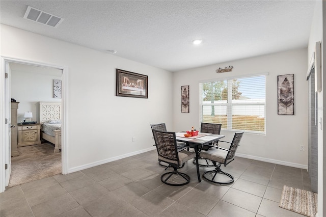 dining room featuring light tile patterned floors and a textured ceiling