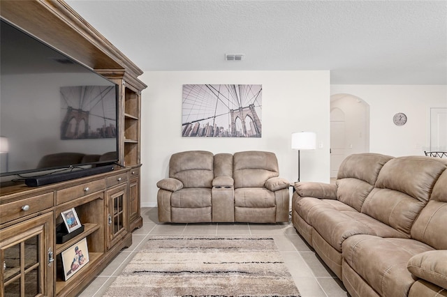 living room featuring light tile patterned flooring and a textured ceiling