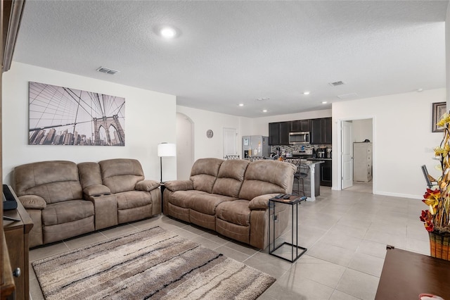 tiled living room with a textured ceiling