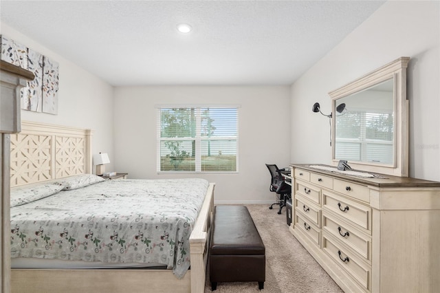 bedroom featuring light colored carpet and a textured ceiling