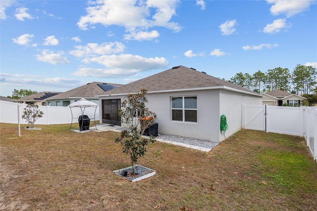 back of property with a patio area and a yard