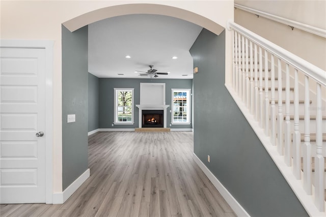 unfurnished living room featuring light wood-type flooring and ceiling fan