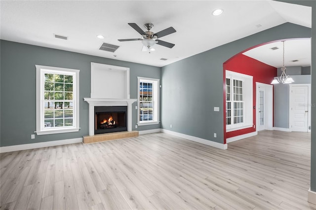 unfurnished living room featuring ceiling fan with notable chandelier, lofted ceiling, and light hardwood / wood-style floors