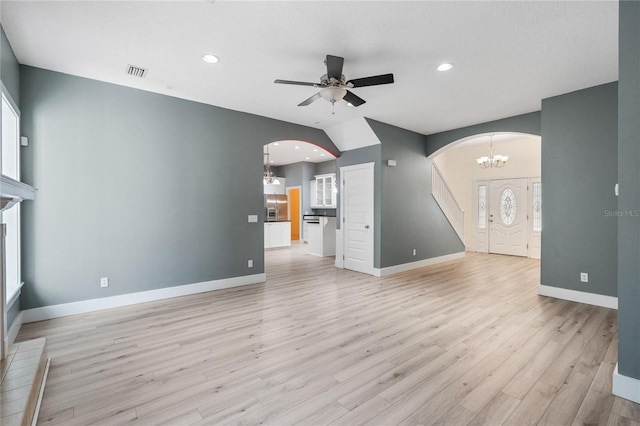 unfurnished living room featuring light hardwood / wood-style flooring and ceiling fan with notable chandelier