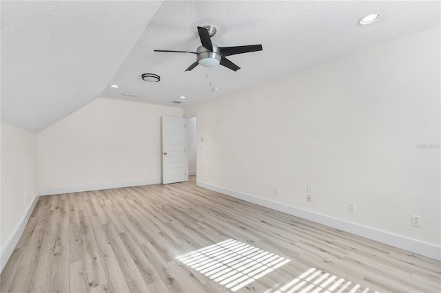 bonus room featuring lofted ceiling, a textured ceiling, and light hardwood / wood-style floors