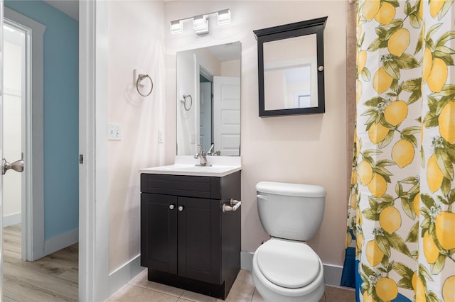 bathroom featuring toilet, walk in shower, and vanity