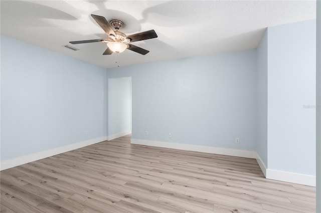 empty room featuring ceiling fan, light hardwood / wood-style flooring, and a textured ceiling