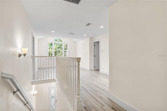 hall with vaulted ceiling and light hardwood / wood-style floors