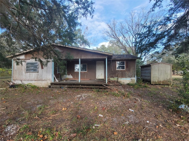 rear view of house with covered porch and a storage shed