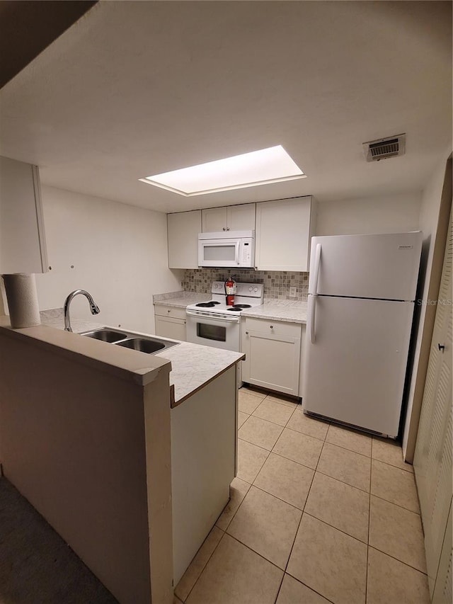 kitchen featuring sink, light tile patterned flooring, backsplash, white appliances, and white cabinets