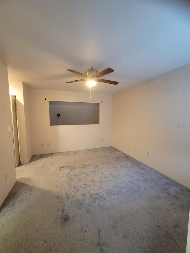 carpeted spare room featuring ceiling fan