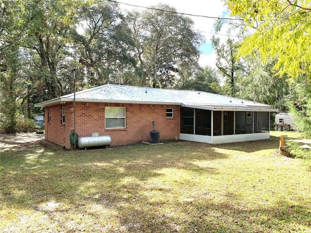 back of house with a sunroom, central AC unit, and a yard