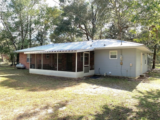 rear view of property with a sunroom and a yard