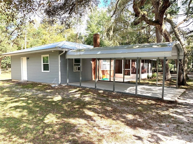 rear view of house featuring a patio and a carport