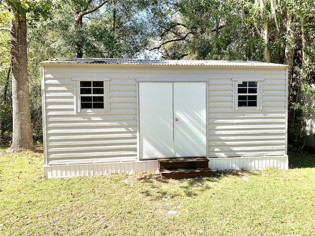 view of outbuilding featuring a yard