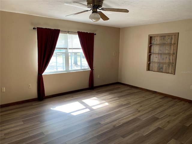 spare room with ceiling fan and dark hardwood / wood-style flooring