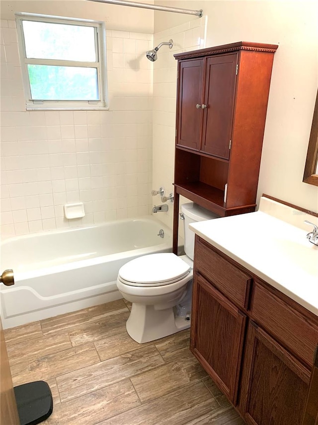 full bathroom featuring toilet, hardwood / wood-style floors, vanity, and tiled shower / bath