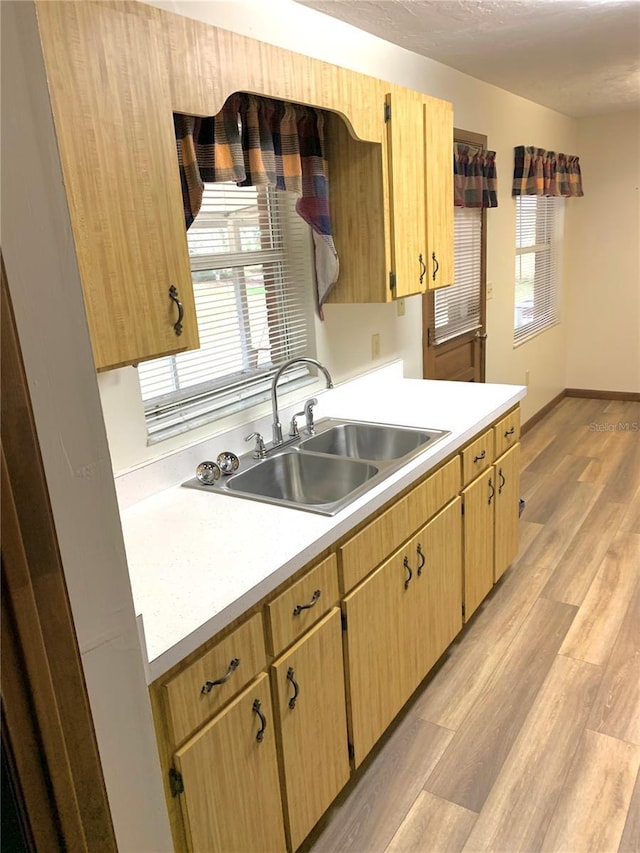 kitchen featuring light wood-type flooring, sink, and light brown cabinetry