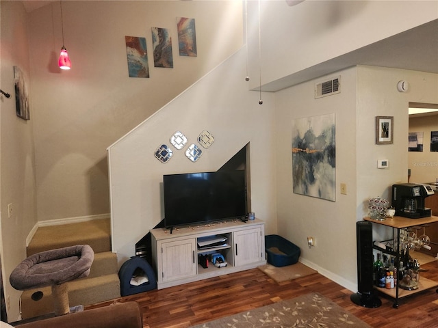 living room with dark wood-type flooring and a high ceiling