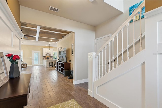 foyer entrance with dark wood-style floors, stairway, visible vents, and baseboards