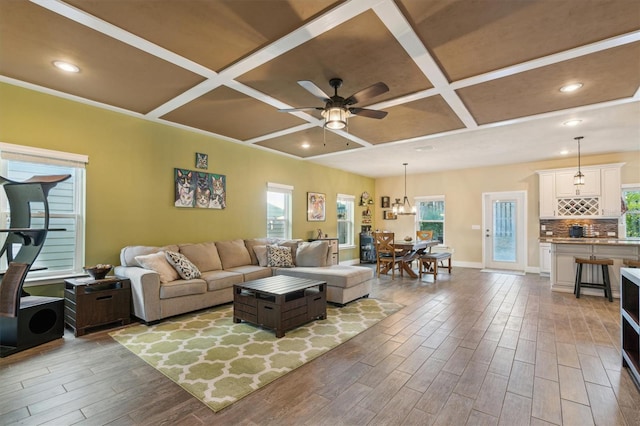 living room with ceiling fan, coffered ceiling, and wood finished floors