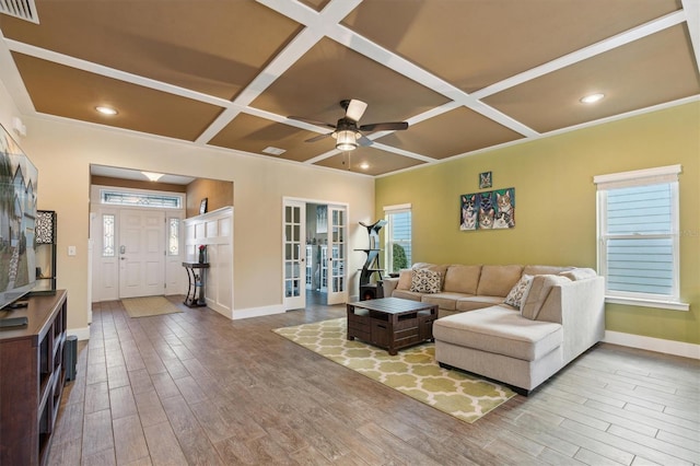 living room featuring coffered ceiling, ceiling fan, and crown molding