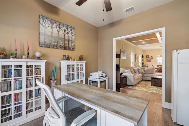 home office with visible vents, a ceiling fan, and wood finished floors