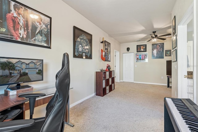 carpeted office featuring a ceiling fan and baseboards