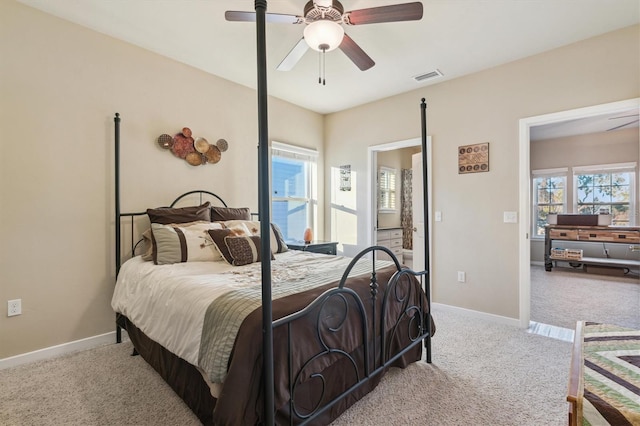 carpeted bedroom featuring visible vents, baseboards, and multiple windows